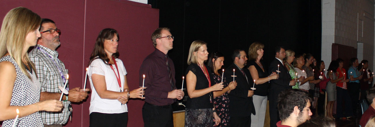 Teachers standing and holding candles